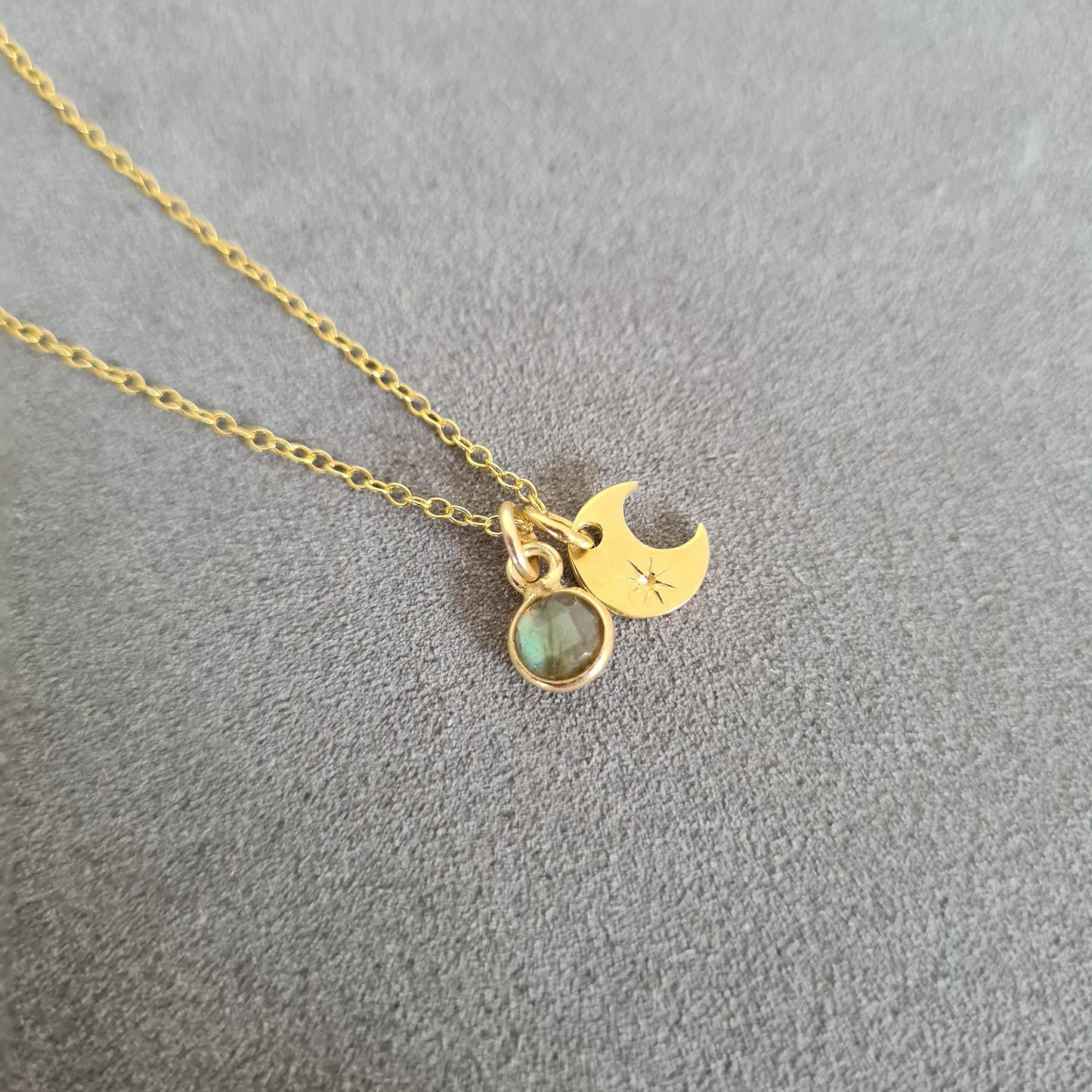 Gold vermeil silver necklace with a crescent moon pendant and labradorite stone pendant on a grey background