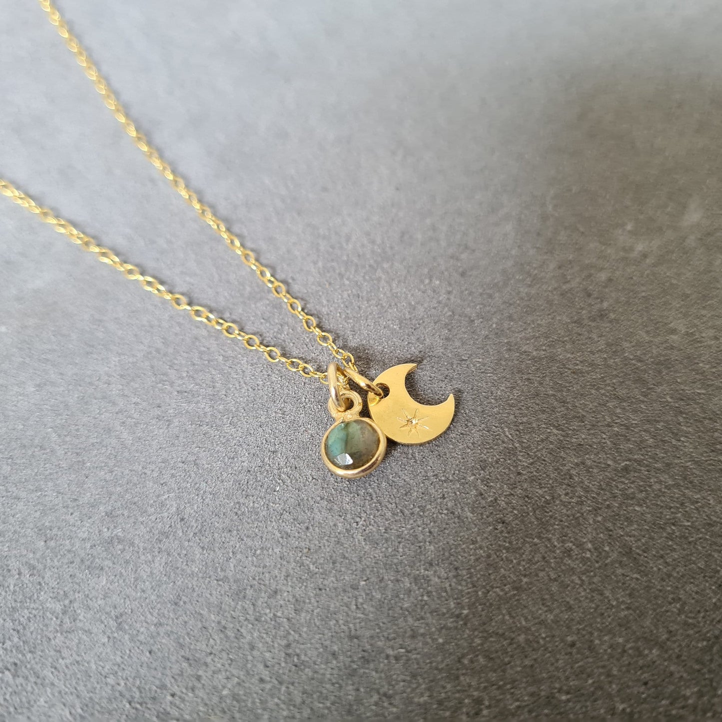 Marie Nicole Bijoux - Woman wearing a gold pendant necklace with a crescent moon and labradorite stone pendants