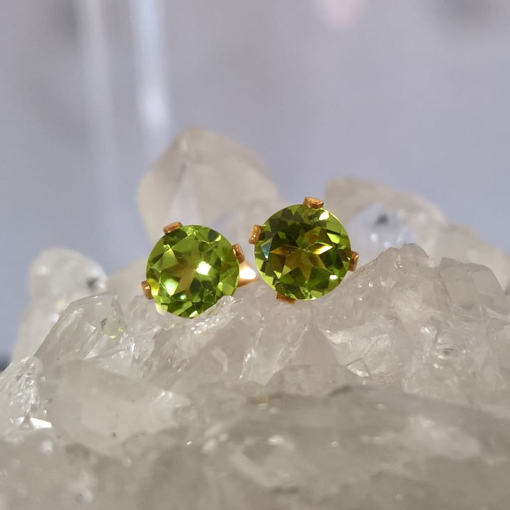 Close up of gold filled peridot stud earrings sitting on a quartz crystal - Marie Nicole Bijoux