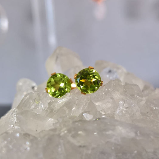 Close up of gold filled peridot stud earrings sitting on a quartz crystal - Marie Nicole Bijoux