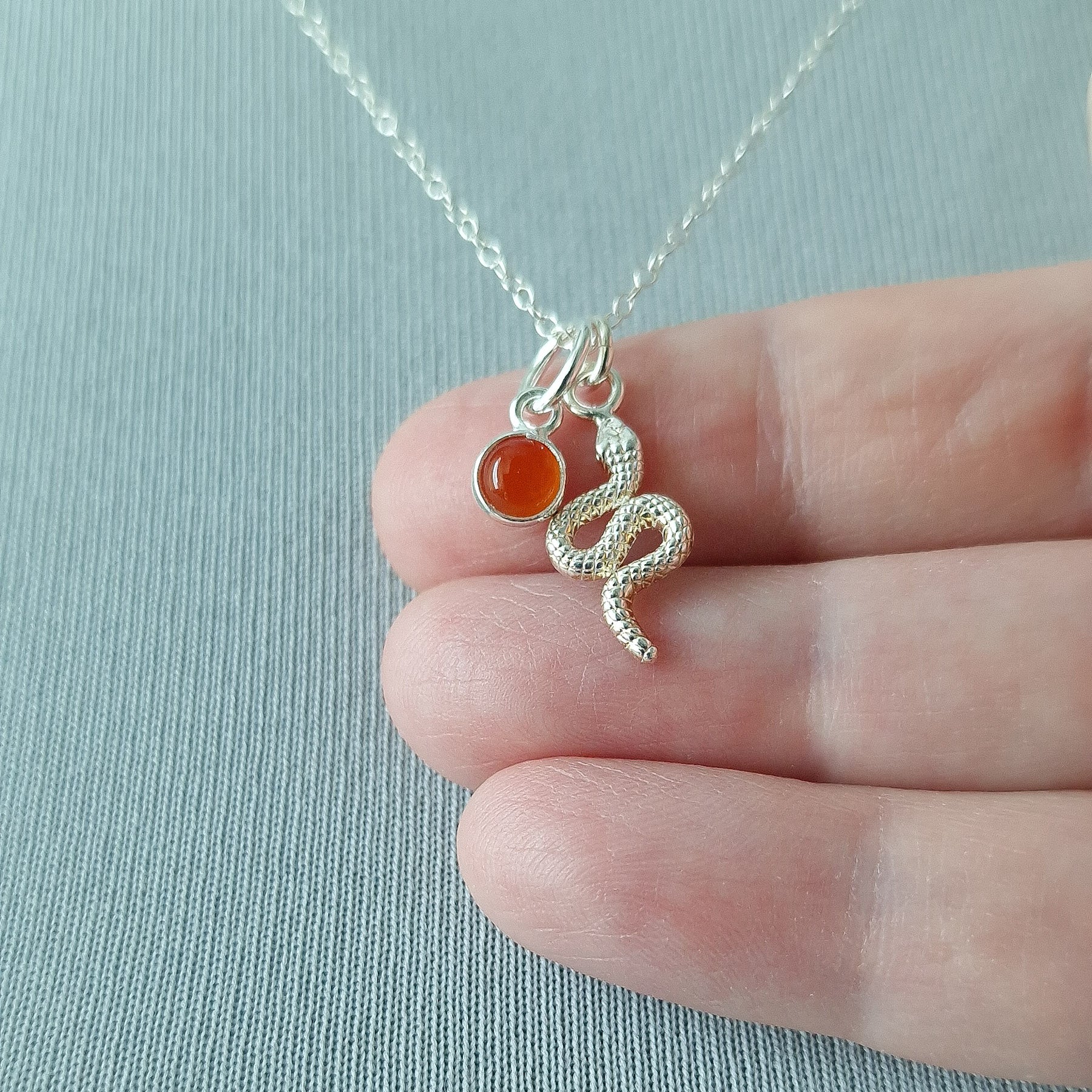 Close up of silver double pendant snake necklace with carnelian birthstone - Marie Nicole Bijoux