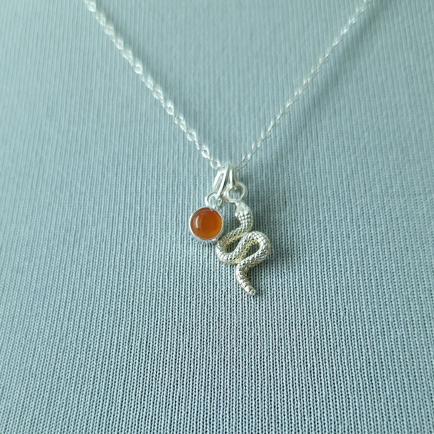 Close up of silver double pendant snake necklace with carnelian birthstone - Marie Nicole Bijoux