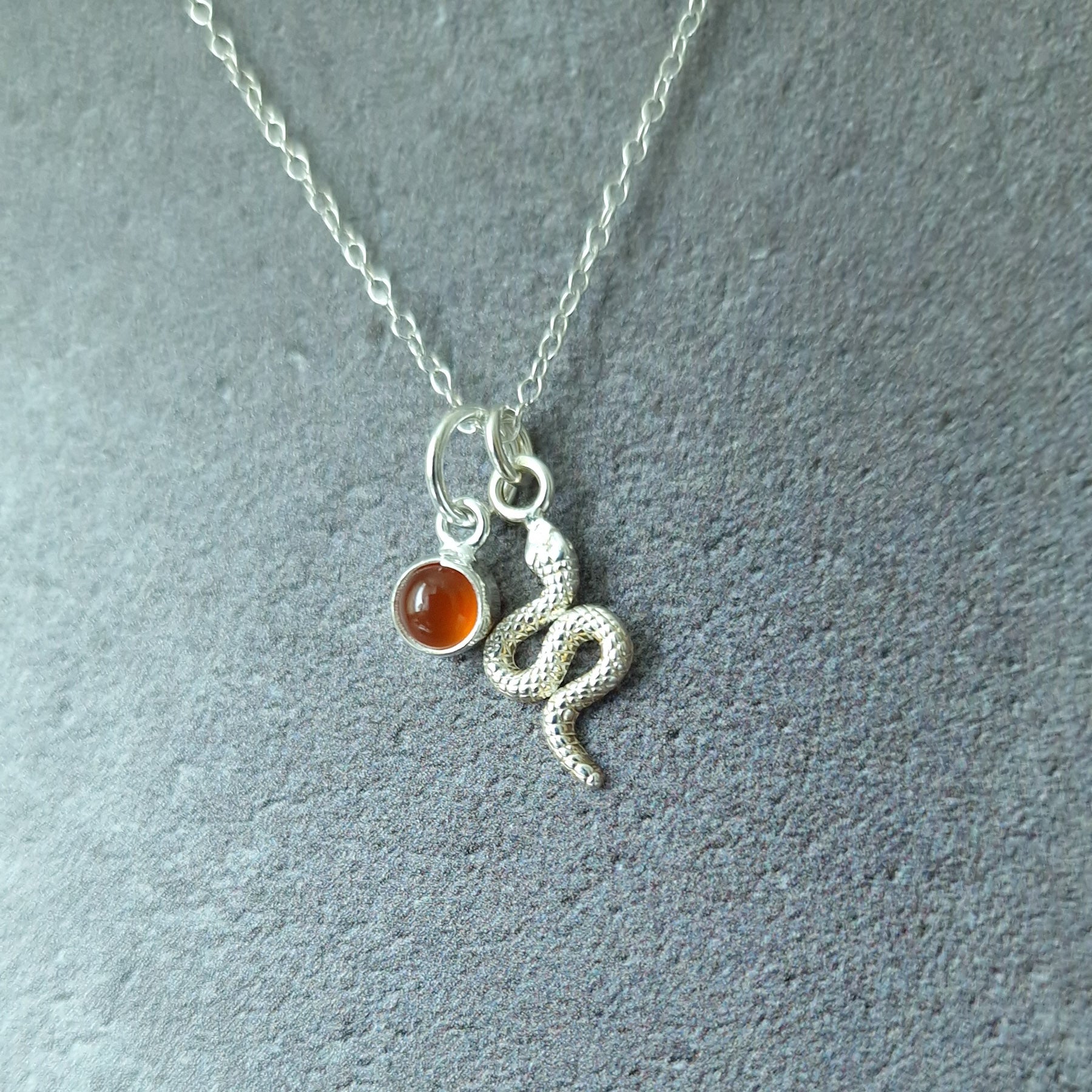 Close up of silver double pendant snake necklace with carnelian birthstone - Marie Nicole Bijoux