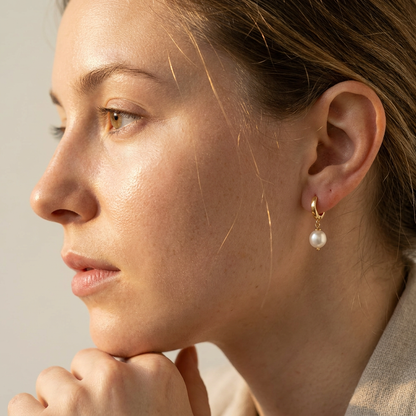 Side profile of woman with gold vermeil pearl huggie hoop earring